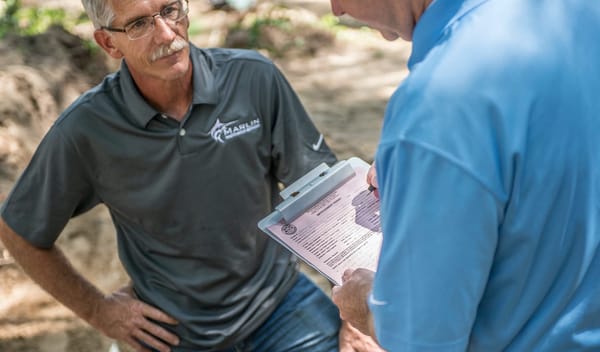A septic installer talks to a regulator on a Septic Installation job site. 
